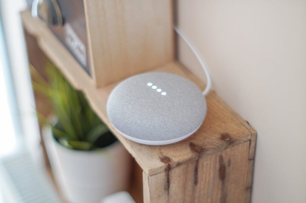 pexels-photo-1072851 A Google Home Mini smart speaker on a wooden shelf, blending technology with home decor.